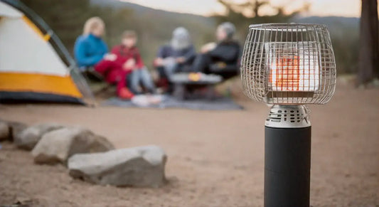 Tragbarer gasheizer auf felsen vor zelt beim campingabenteuer