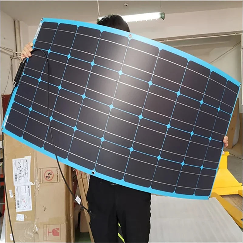 Ein solarmodul mit einem hellblauen rahmen wird hochgehalten.