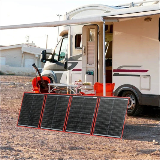 Wohnmobil (rv) mit sonnenkollektoren und einer gitarre im freien.