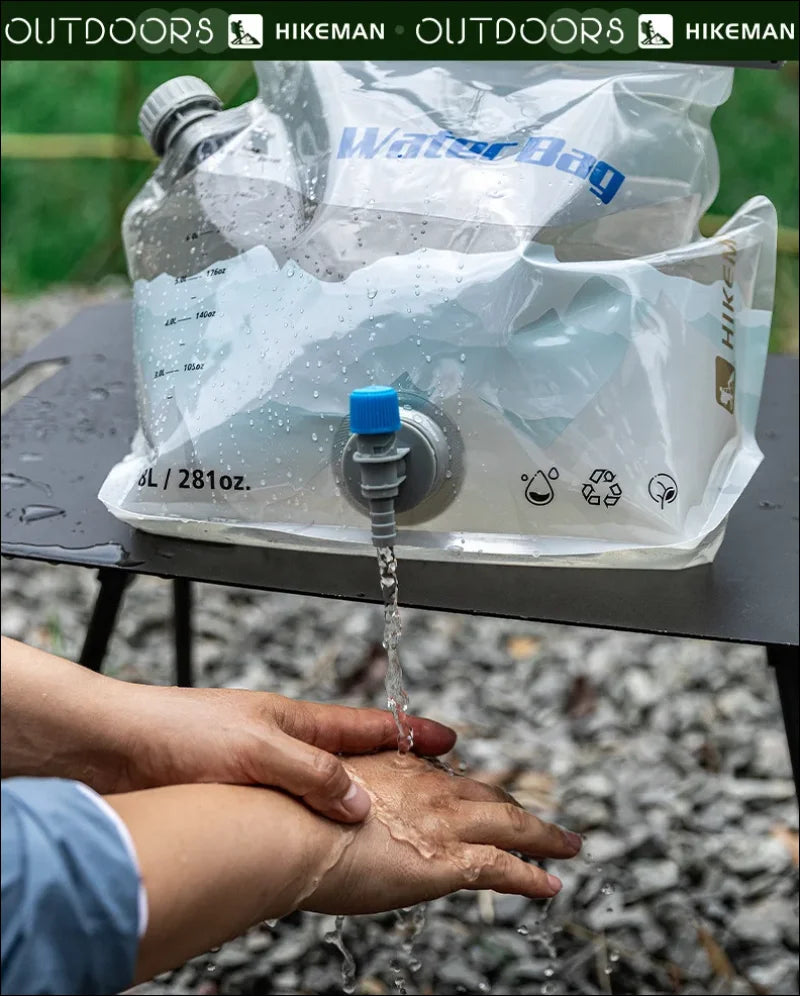 Zusammenklappbarer wasserbehälter mit einem ausguss, der wasser auf die hände abgibt.