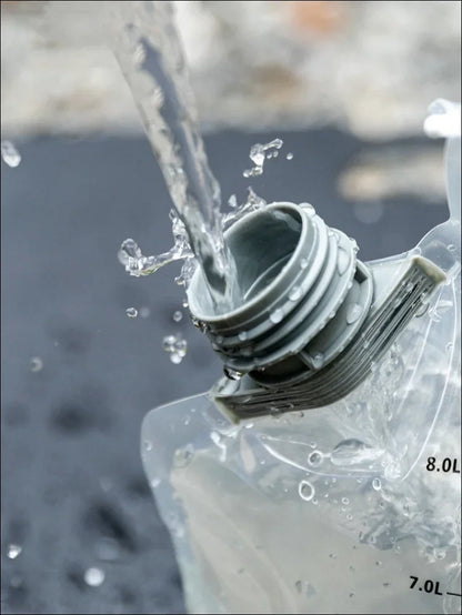 Plastikwasserflasche, aus deren offenem deckel wasser herausspritzt.