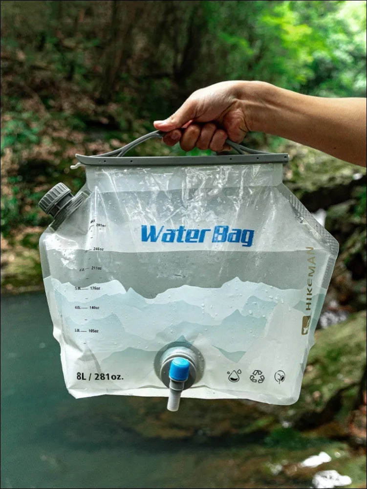 Tragbarer wasserbehälter mit ausgießer und griff, beschriftet mit ’water bag’.