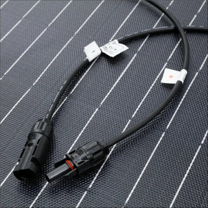 Schwarzes kabel mit steckern an beiden enden, wahrscheinlich für elektro- oder solarmodule geeignet.