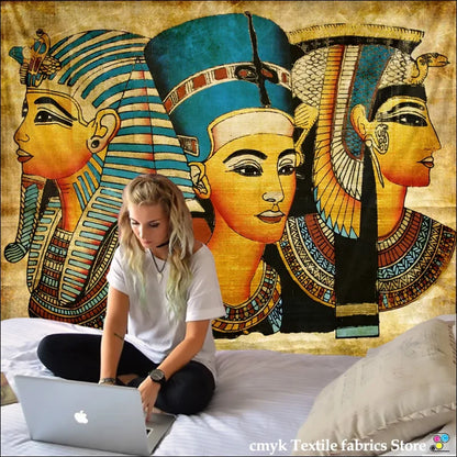 Eine frau sitzt auf einem bett mit laptop vor einem ägyptischen tribal wandteppich