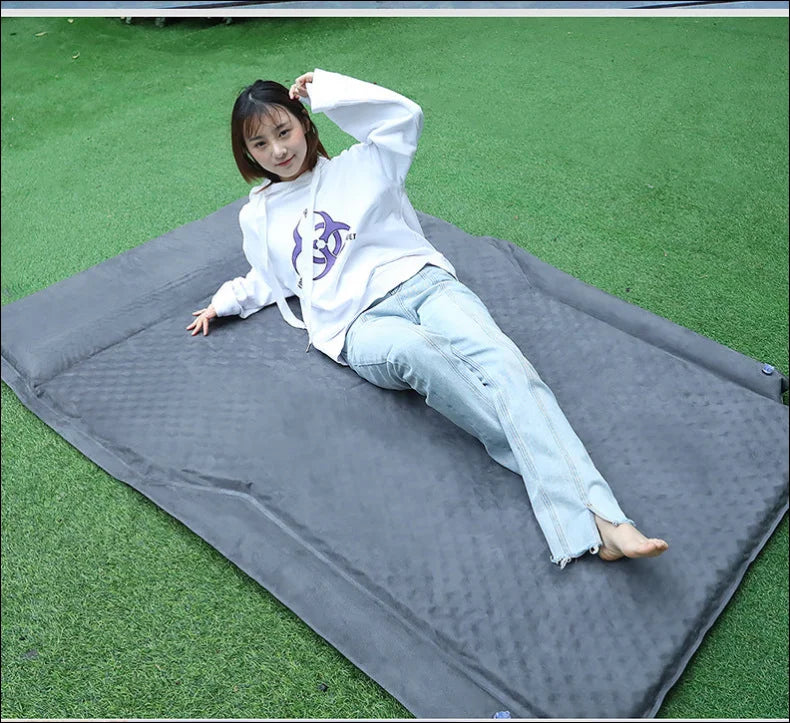 Mädchen sitzt auf einer matte im gras - ultimativer schlafkomfort: matratze bietet ihnen