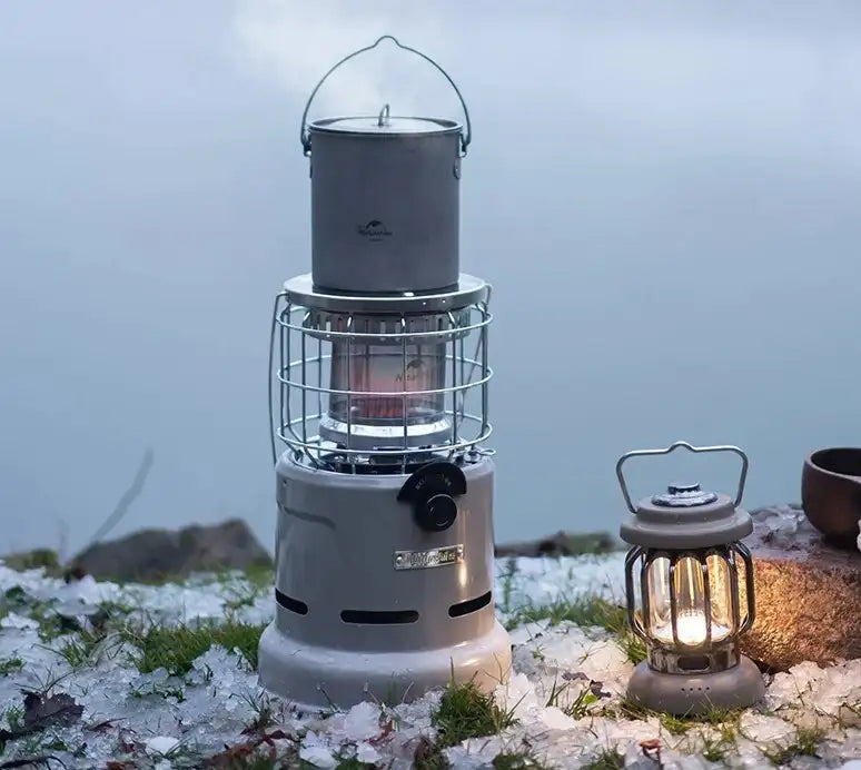 ein campingkocher steht auf einem grossen campingkocher und eine Gaslampe steht daneben