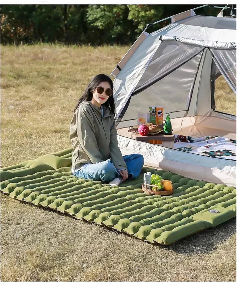 Frau auf doppelte Camping-Schlafmatte 130x190cm mit Essen und Trinken vor Zelt