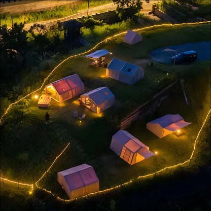 Illuminierter campingplatz mit großen aufblasbaren zelten und lichterketten in der nacht