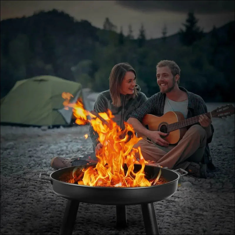 Paar am lagerfeuer in einer feuerstelle, spielt gitarre, perfekt zum grillen bei 500°c