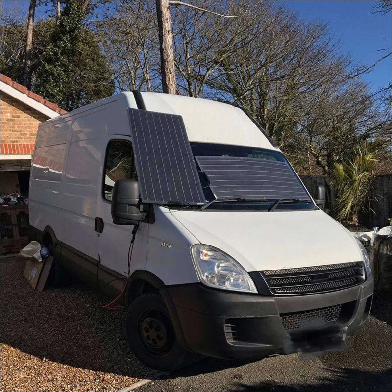 Weiße transporter mit solarfläche „flexibles solarpanel zum erweitern“ auf der windschutzscheibe