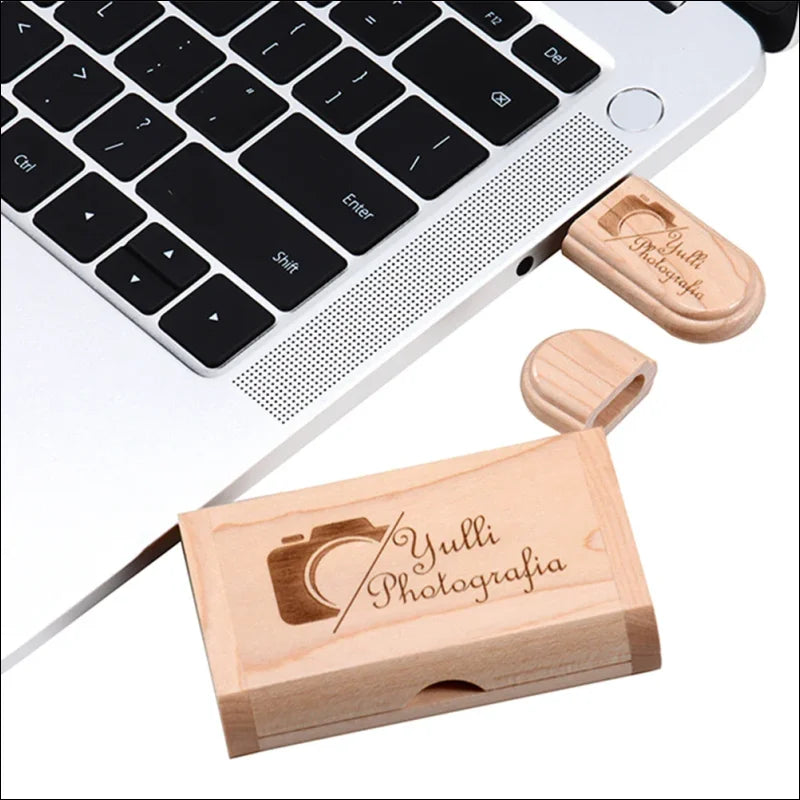 Usb-stick aus holz mit der gravur ’yulli photografia’ und einem kamerasymbol.