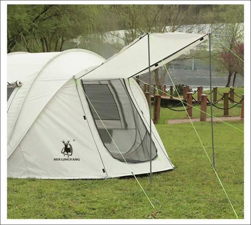 Weißes campingzelt mit verlängertem regenüberzug und netzfenster.