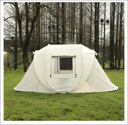 Weißes pop-up-zelt mit quadratischem fenster auf grasbewachsenem boden.