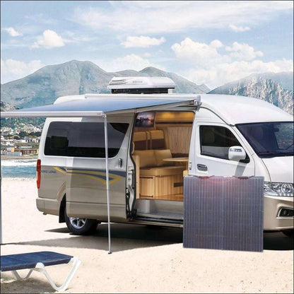 Ein van am strand mit tisch und stühlen, perfekt für das flexible solarpanel-kit für wohnmobile