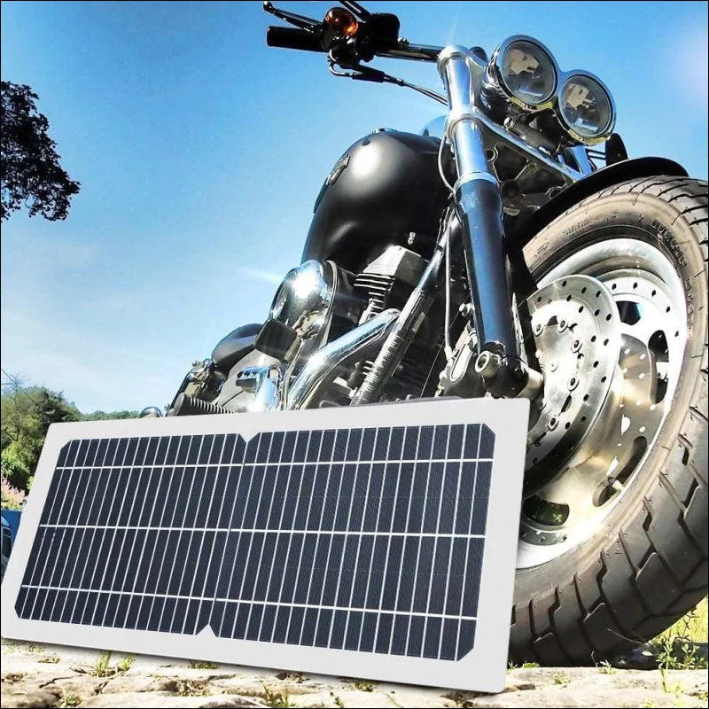 Motorrad mit tragbarem solarpanel lädt ihr handy schnell auf.