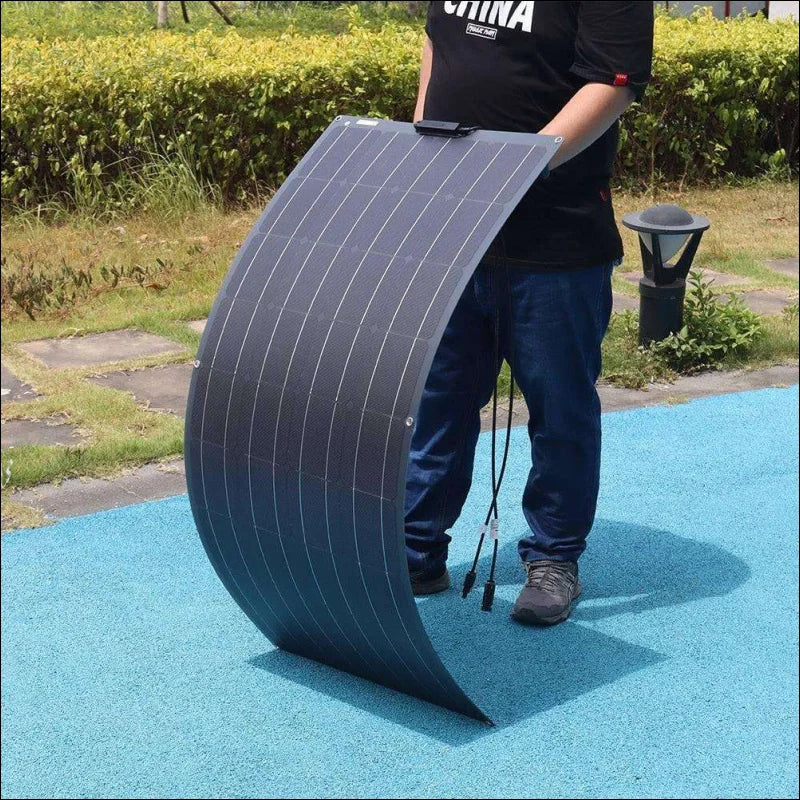 Ein mann hält ein großes schwarzes plastikobjekt, das flexibles solarpanel kit