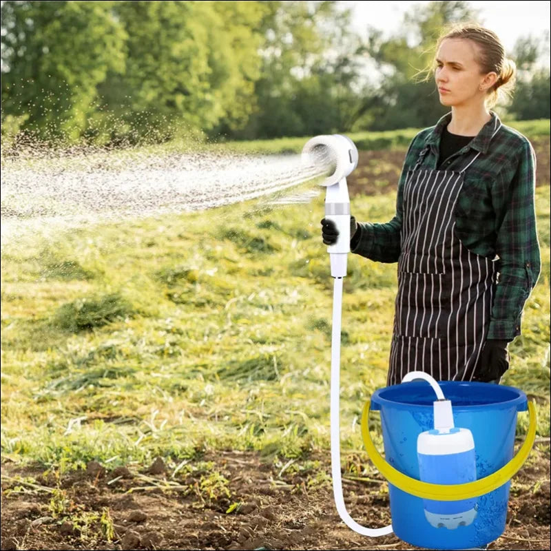 Handheld electric water pump sprüht Wasser aus blauem Eimer, ideal für tragbare Campingdusche