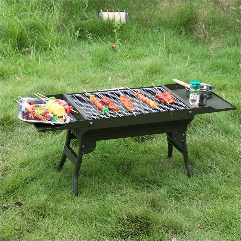 Tragbarer holzkohlegrill, bei dem die speisen auf dem rost gegart werden und eine seitliche ablage für die zutaten vorhanden ist.