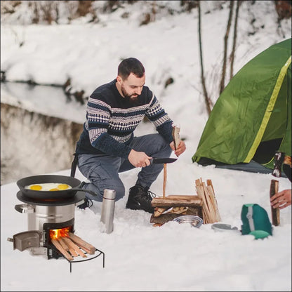 Ein mann zeltet im schnee und kocht eier auf einem tragbaren herd in der nähe eines zeltes.