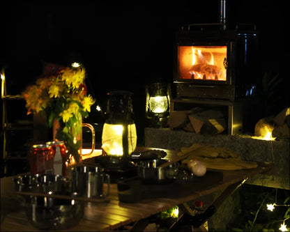 Ein tisch mit blumen und kerzen neben einem mini kamin im freien für holzofen