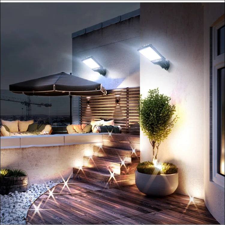 Ein patio mit tisch und stühlen unter einem schirm, beleuchtet durch solarleuchten mit bewegungssensor